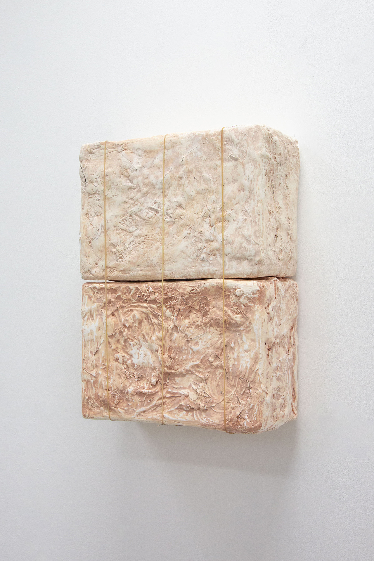 image of two plaster boxes stained with terracotta clay on top of each other, attached together with three rubber bands